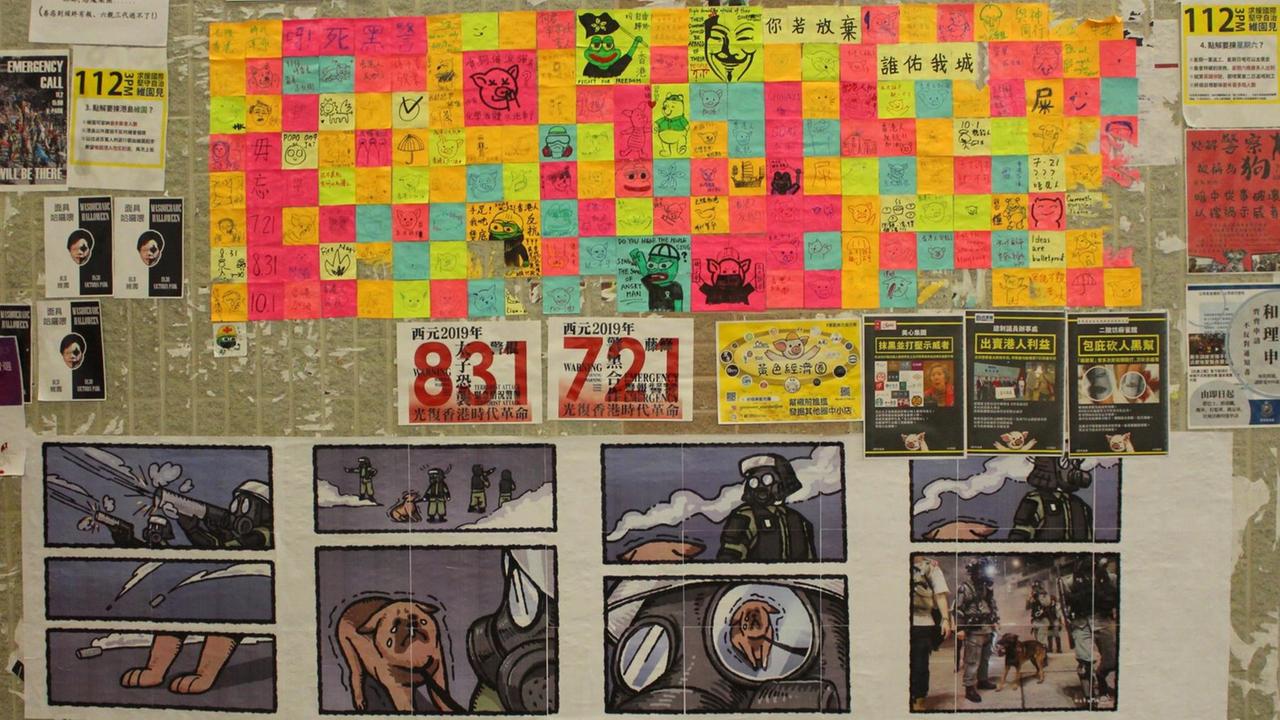 Mit Protestplakaten, Comic Strips und handschriftlichen Notizen bunt beklebte Wand an einer U-Bahn-Station in Hongkong, auf der die Demoktatiebewegung Nachrichten, unterdrückte Informationen und künstlerische Statements veröffentlicht. 