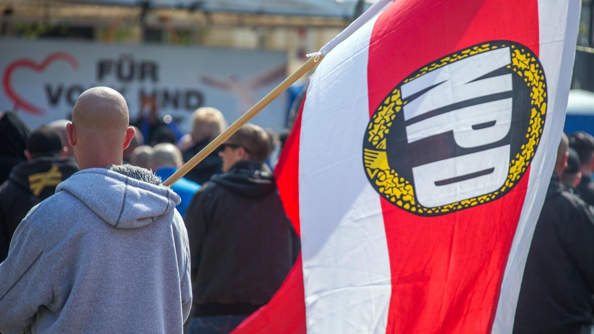 Teilnehmer einer Kundgebung der NPD, einer trägt eine NPD-Flagge. Teilnehmer einer Kundgebung der NPD, einer trägt eine NPD-Flagge.