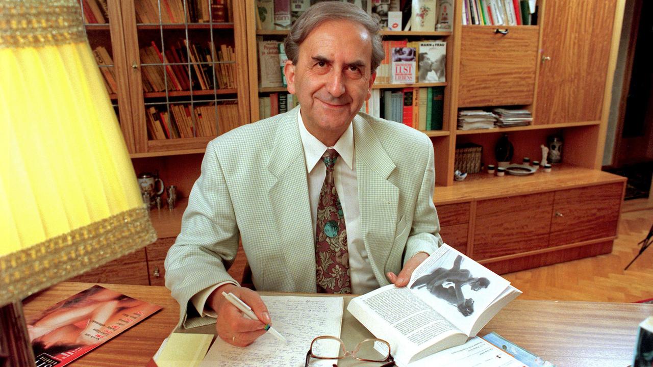 Der ostdeutsche Sexualaufklärer Dr. Siegfried Schnabl sitzt an einem Schreibtisch vor einer Bücherwand.