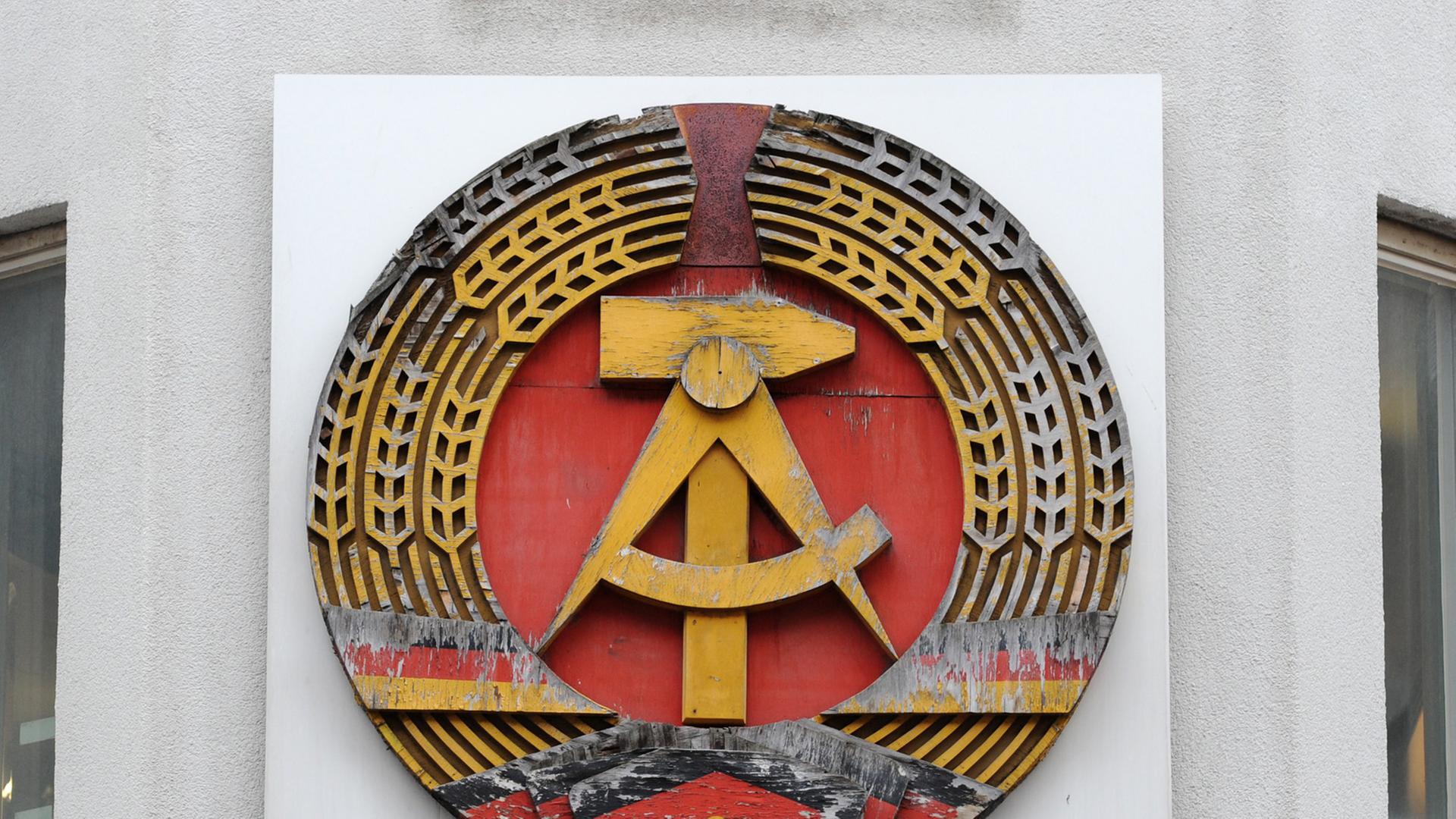 Ein DDR-Emblem hängt am Mauermuseum - Haus am Checkpoint Charlie in Berlin. Ein DDR-Emblem hängt am Mauermuseum - Haus am Checkpoint Charlie in Berlin.
