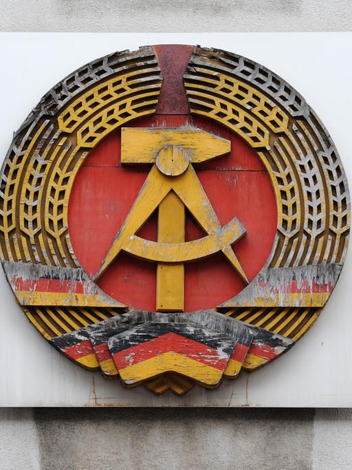 Ein DDR-Emblem hängt am Mauermuseum - Haus am Checkpoint Charlie in Berlin.