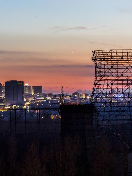 Panorama der Innenstadt von Essen, Skyline vor Abendhimmel, vorne Kühlturmgerüste der Kokerei Zollverein
