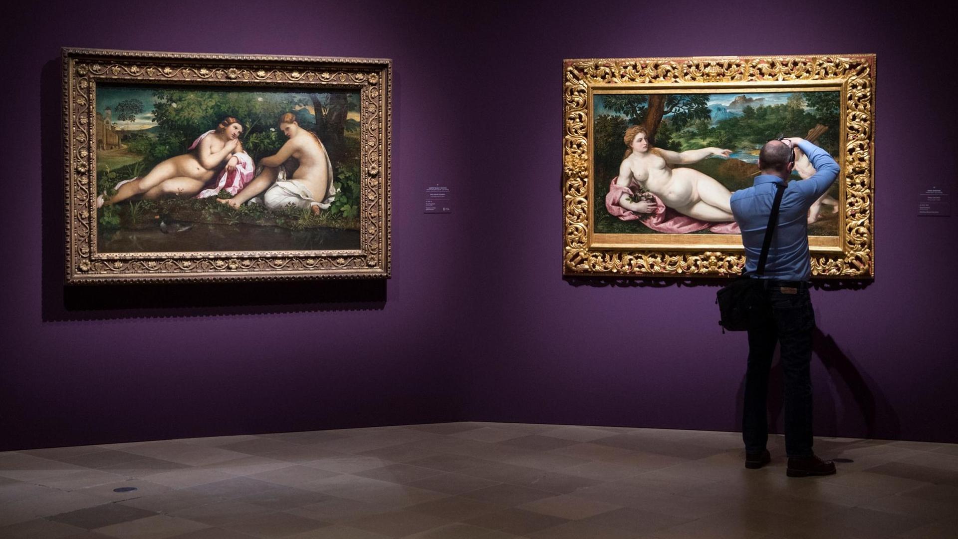 Ein Mann fotografiert in der Ausstellung "Tizian und die Renaissance in Venedig" im Städel ein Detail eines Bildes.