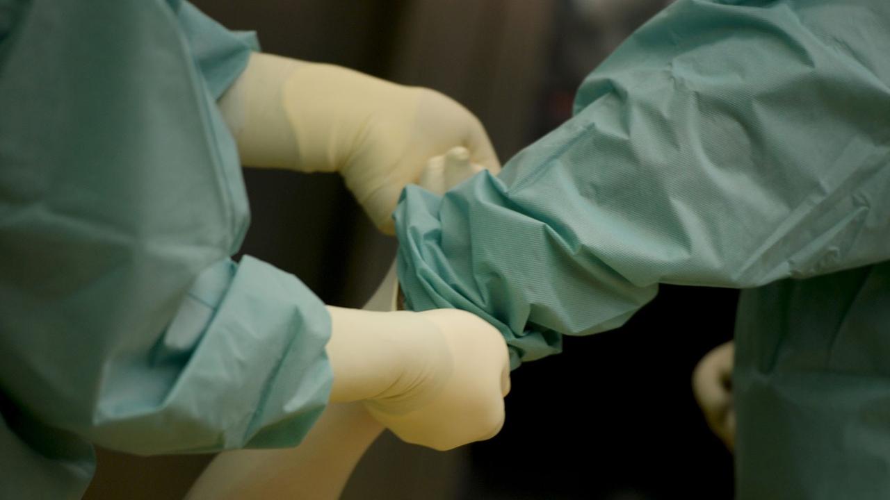 Ein Mediziner bekommt am 18.02.2014 in einer Klinik in Baden-Württemberg vor einer Operation ein Paar Handschuhe angezogen. Ein Mediziner bekommt am 18.02.2014 in einer Klinik in Baden-Württemberg vor einer Operation ein Paar Handschuhe angezogen.
