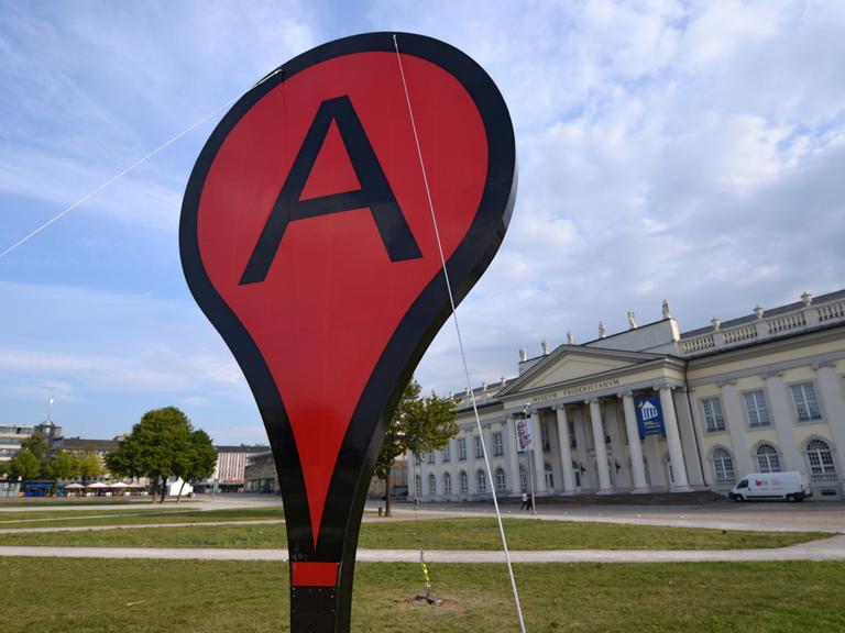 Ein riesiges Google Maps-Markierungszeichen steht auf dem Friedrichsplatz in Kassel.