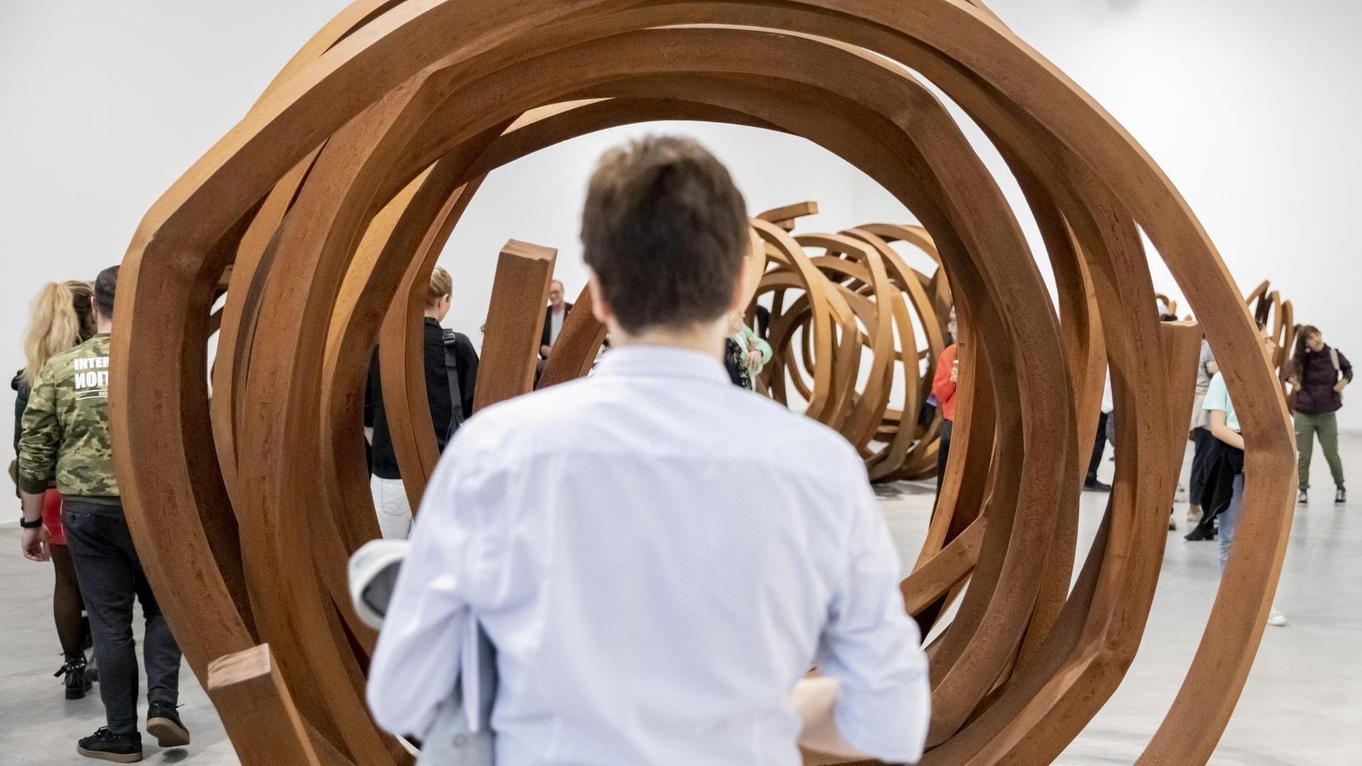 Ein Mann schaut sich beim "Gallery Weekend" Berlin ein röhrenförmiges Werk an.