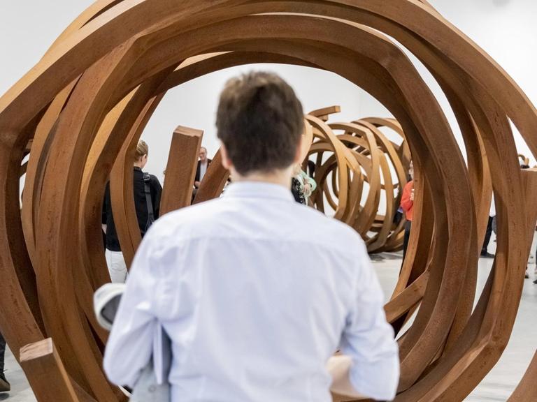 Ein Mann schaut sich beim "Gallery Weekend" Berlin ein röhrenförmiges Werk an.