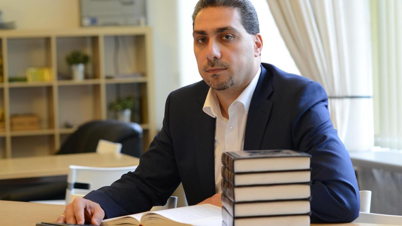 Der Zahnarzt Sadiqu Al-Mousllie sitzt am Schreibtisch Der Zahnarzt Sadiqu Al-Mousllie sitzt am Schreibtisch