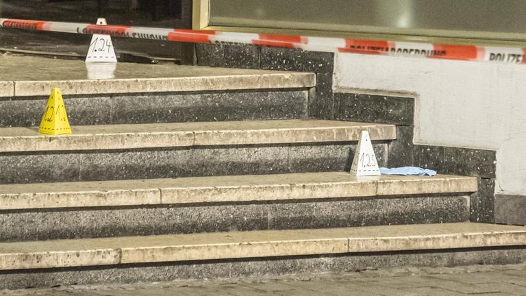 Die Spurensicherung der Polizei am Tatort in Hanau am Mittwochabend, 19.02.2020. Pappschilder mit Zahlen stehen auf einer Treppe, an dem die Opfer des rechtsextremes Anschlags lagen.