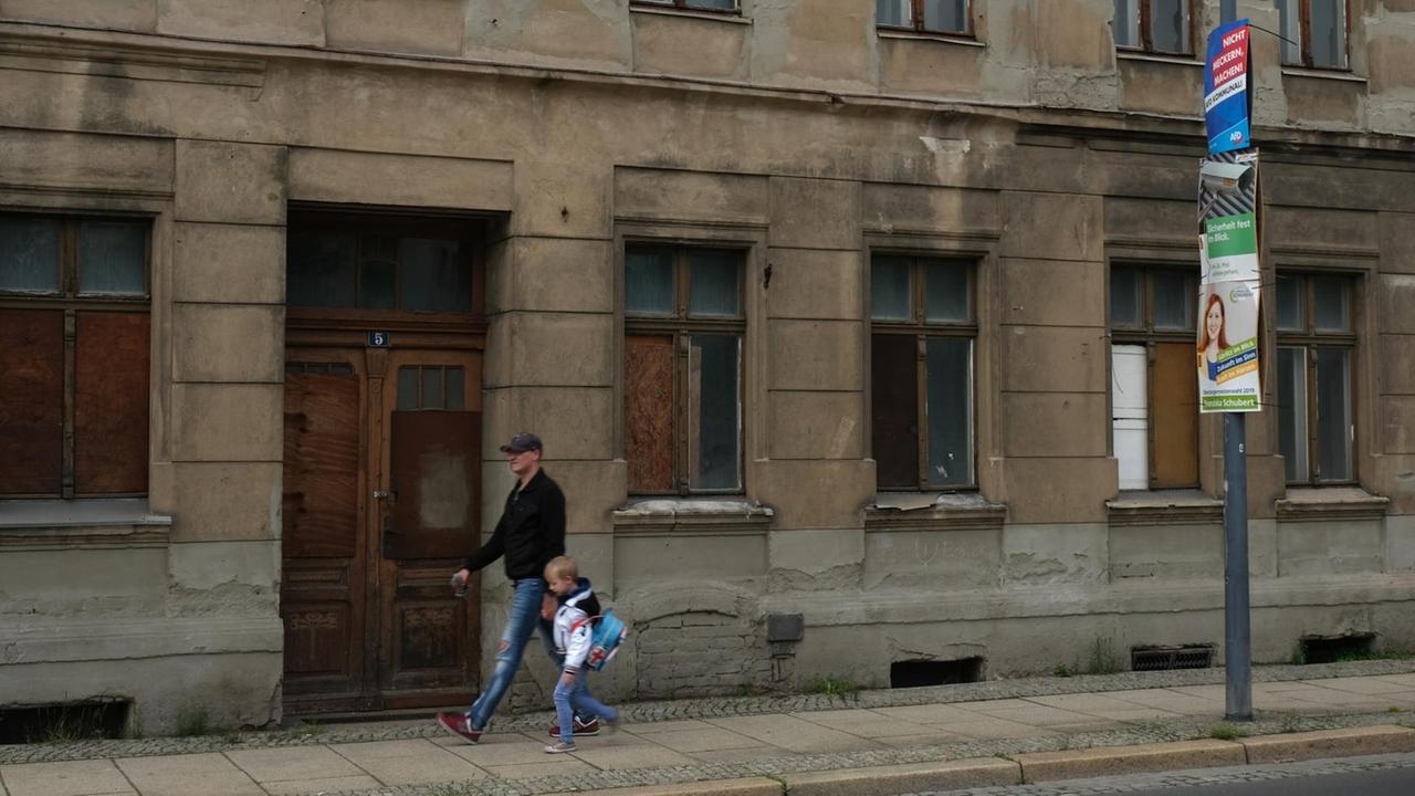 Ein Mann mit seinem Kind passiert ein Gebäude in desolatem Zustand im Mai 2019 in der ostdeutschen Grenzstadt Görlitz. Ein Mann mit seinem Kind passiert ein Gebäude in desolatem Zustand im Mai 2019 in der ostdeutschen Grenzstadt Görlitz.