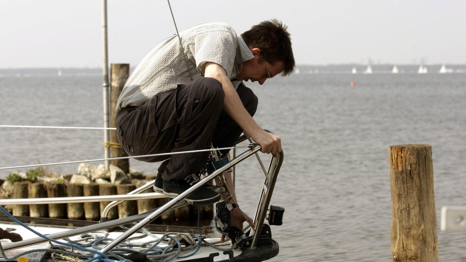 Ein Segler bereitet sein Boot vor