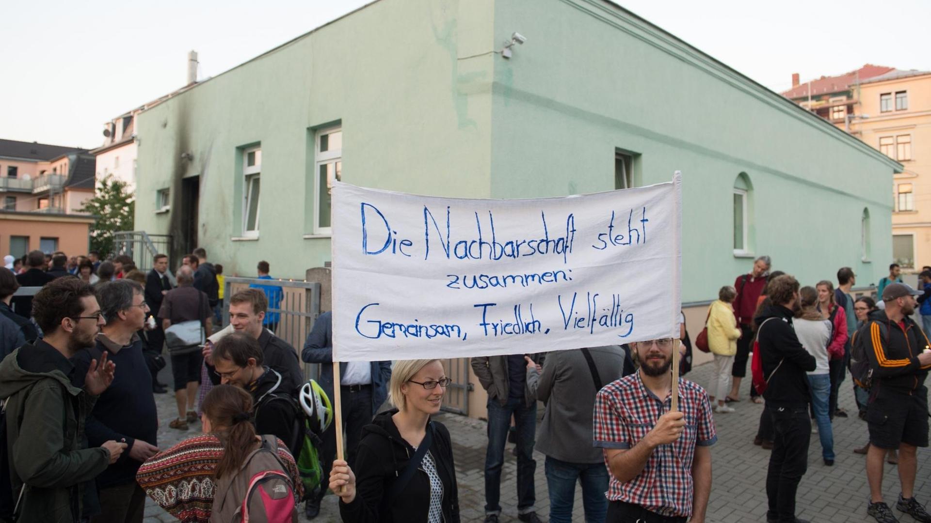 Teilnehmer halten in Dresden eine Mahnwache vor der Fatih-Moschee.