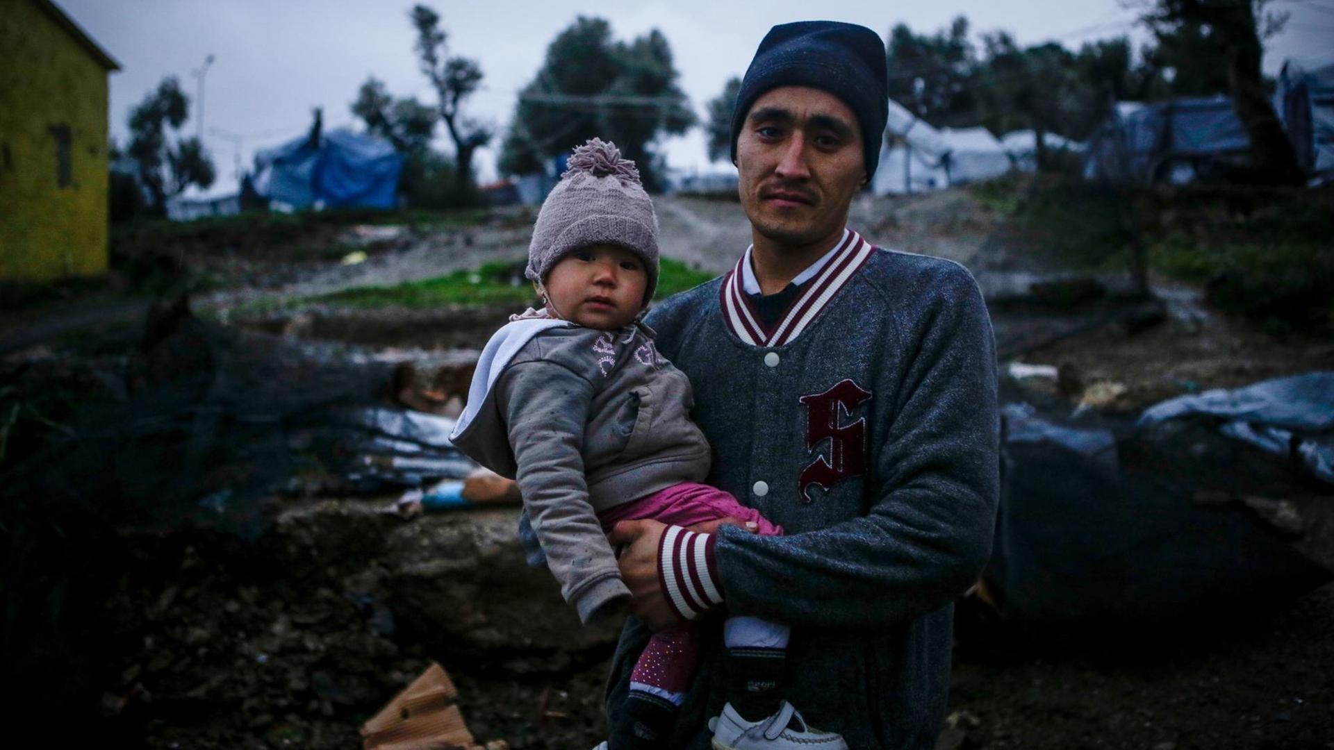 Das Bild zeigt einen Flüchtling mit Kind im Flüchtlingslager Moria auf Lesbos. Das Bild zeigt einen Flüchtling mit Kind im Flüchtlingslager Moria auf Lesbos.