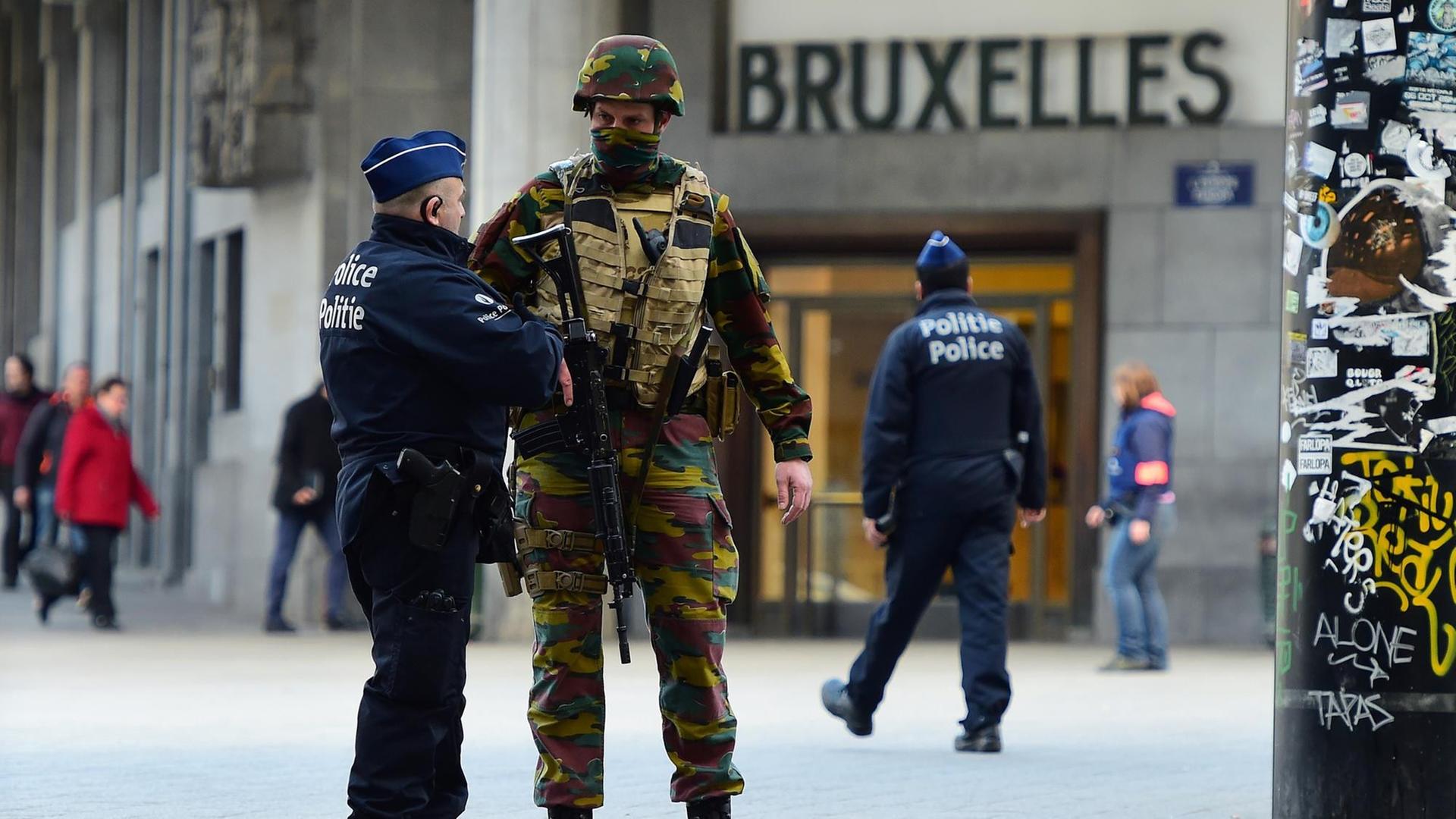 Ein Polizist und ein schwer bewaffneter Soldat unterhalten sich vor dem Brüsseler Hauptbahnhof am 22.03.2016. Ein Polizist und ein schwer bewaffneter Soldat unterhalten sich vor dem Brüsseler Hauptbahnhof am 22.03.2016.