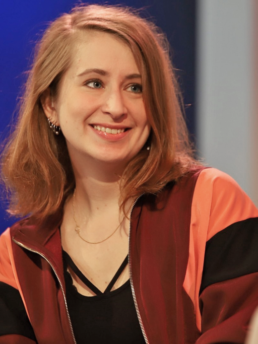 Die Autorin Margarete Stokowski lächelt die Moderatorin auf dem Blauen Sofa auf der Frankfurter Buchmesse 2018 an.