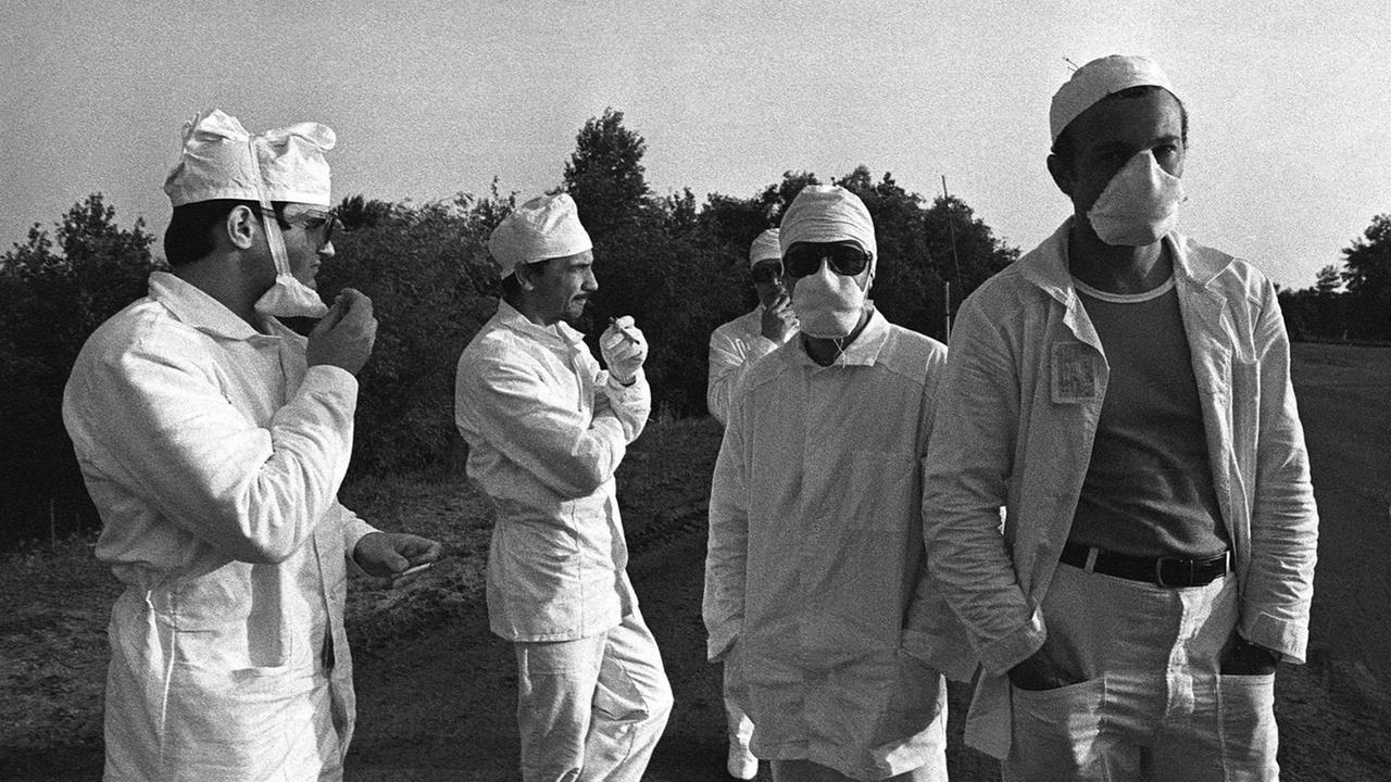 Eine historische schwarz-weiß-Aufnahme zeigt eine Grupper sogenannter Liquidatoren während der Aufräumarbeiten nach der Katastrophe von Tschernobyl.