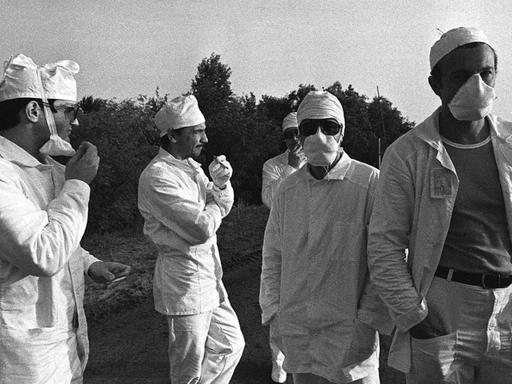 Eine historische schwarz-weiß-Aufnahme zeigt eine Grupper sogenannter Liquidatoren während der Aufräumarbeiten nach der Katastrophe von Tschernobyl.