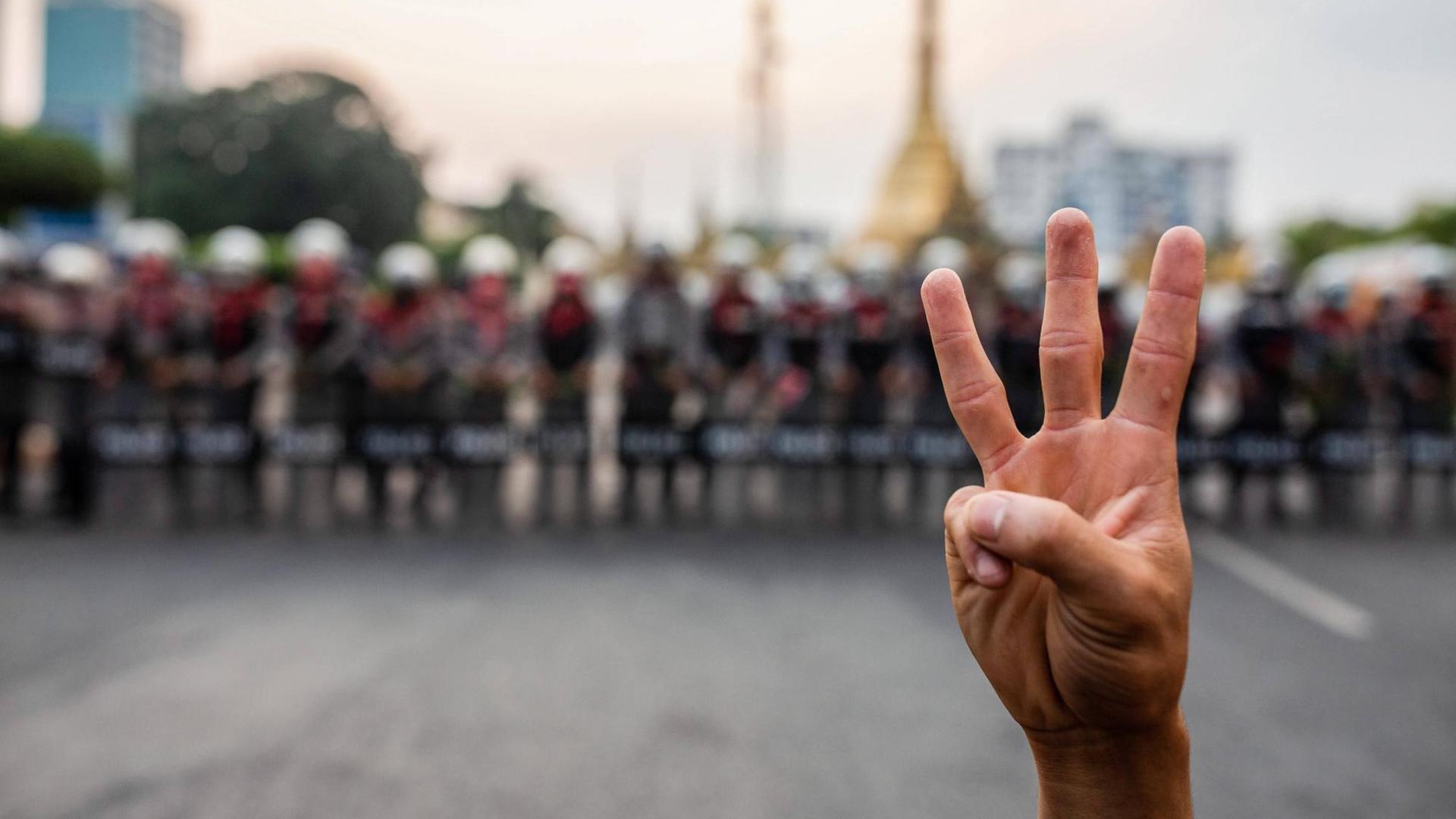 drei Finger einer Hand hochgestreckt bei Protesten in Myanmar drei Finger einer Hand hochgestreckt bei Protesten in Myanmar