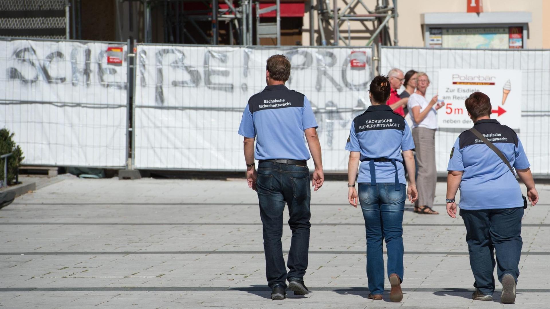 Mitarbeiter der Sächsischen Sicherheitswacht gehen über den Kornmarkt in Bautzen.