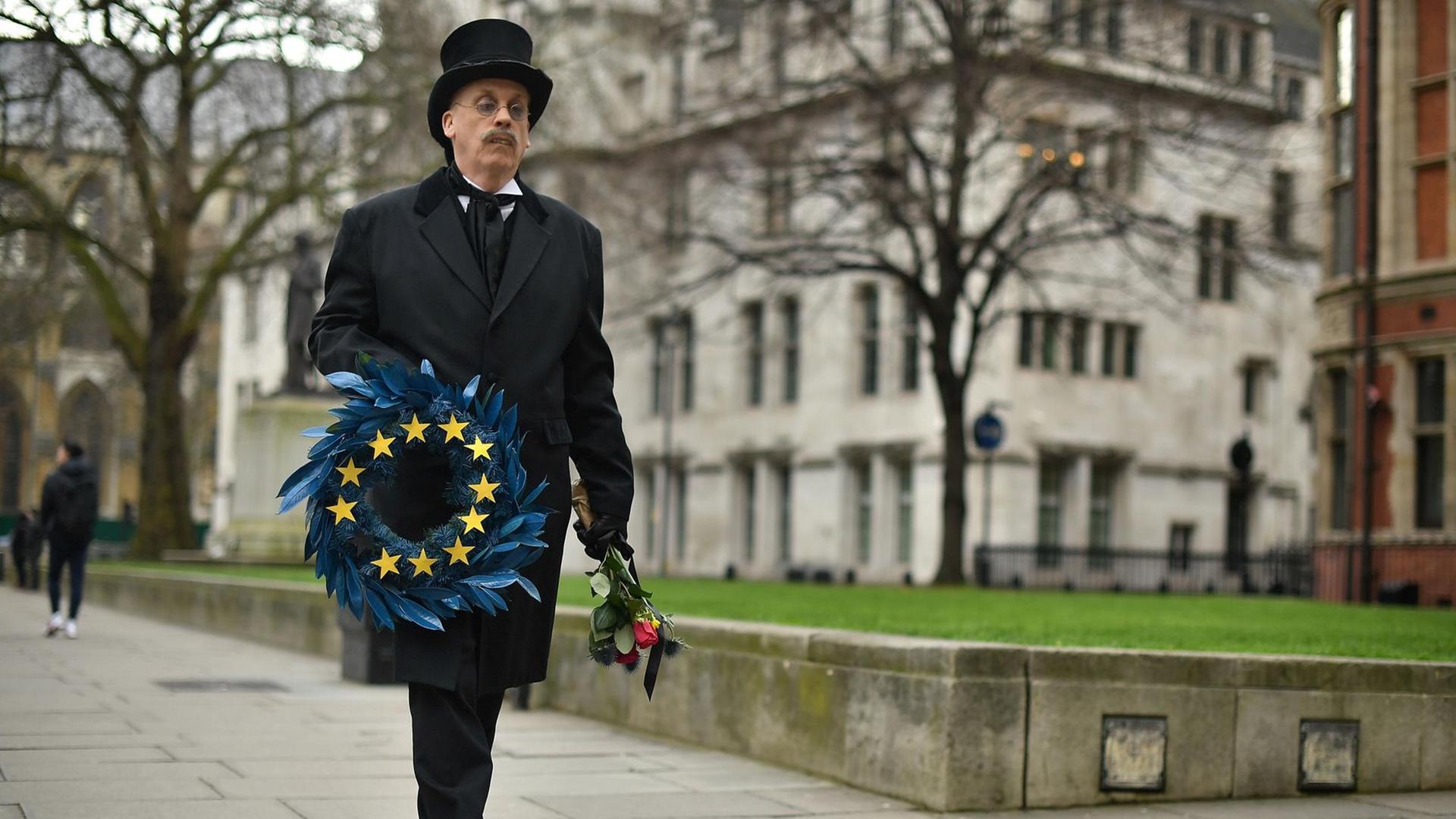 Auf dem Foto trägt ein Mann in London die EU symbolisch zu Grabe. Auf dem Foto trägt ein Mann in London die EU symbolisch zu Grabe.