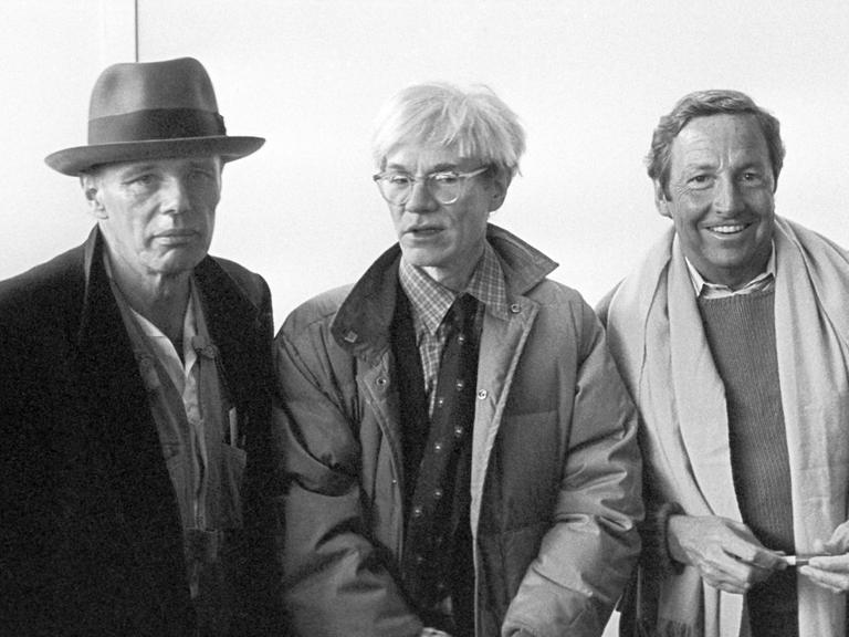Die Künstler Joseph Beuys (l), Andy Warhol (M) und Robert Rauschenberg bei der Pressekonferenz am 03.03.1982 anlässlich ihrer Ausstellungseröffnung. Die Ausstellung "Beuys, Rauschenberg, Twombly, Warhol - Die Sammlung Dr. Erich Marx" wurde am 02. März 1982 in der Nationalgalerie eröffnet und dauerte bis zum 04. April.