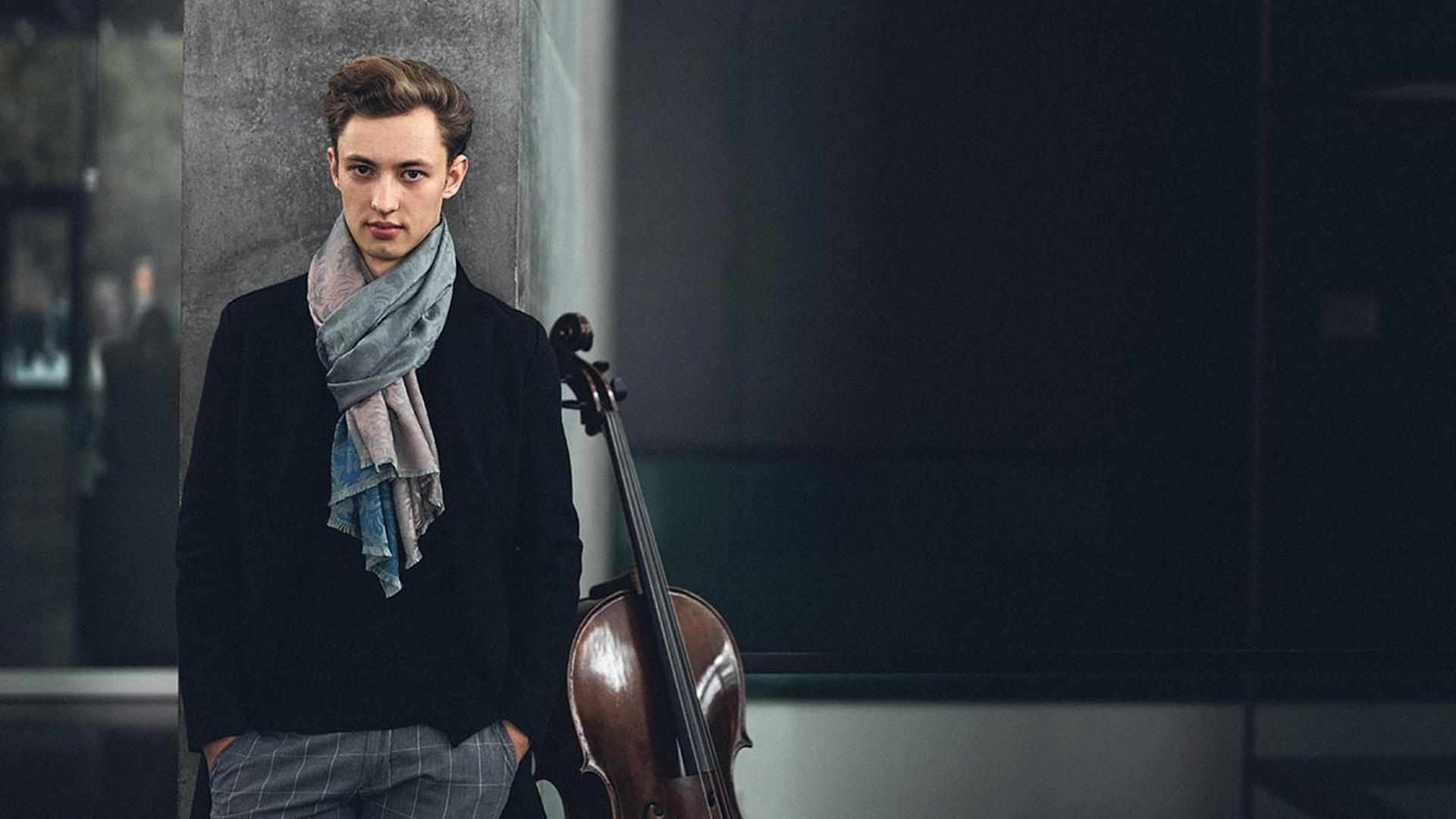 Der Cellist steht angelehnt an eine Wand in einem Treppenhaus, neben ihm ist sein Cello platziert. Der Cellist steht angelehnt an eine Wand in einem Treppenhaus, neben ihm ist sein Cello platziert.