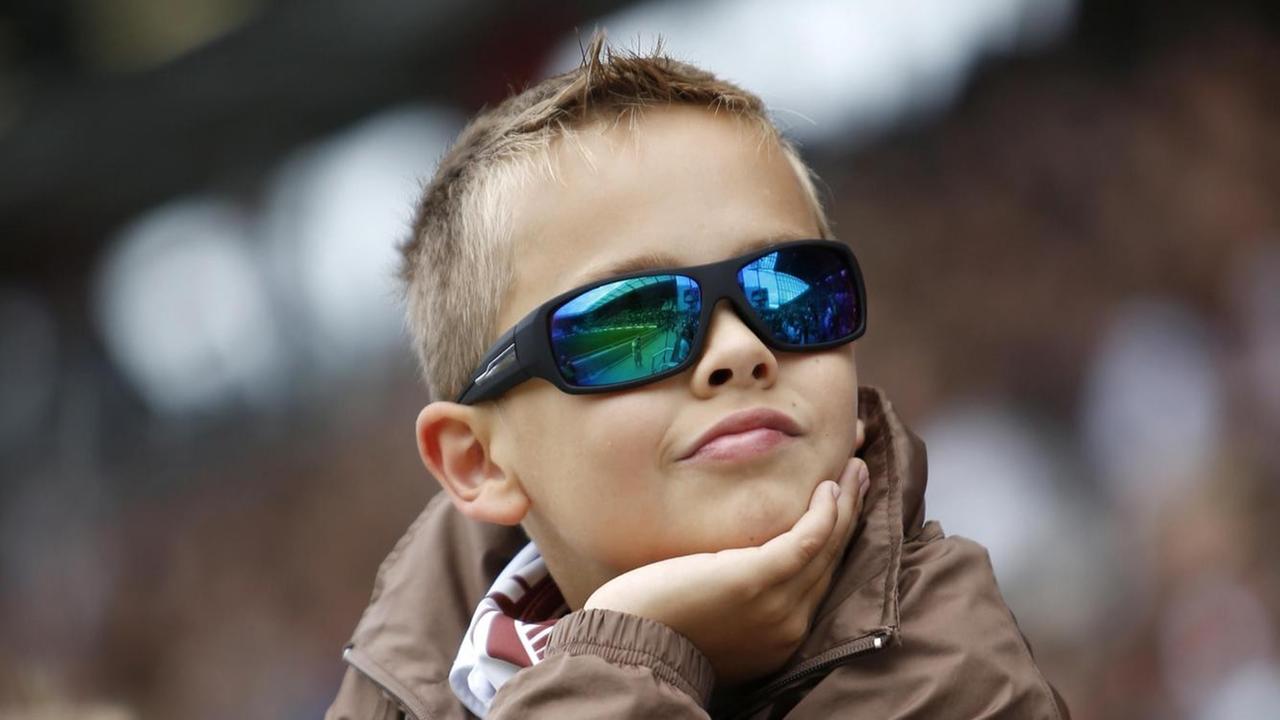 Das Foto zeigt einen jungen Fußball-Fan mit verspiegelter Sonnenbrille.