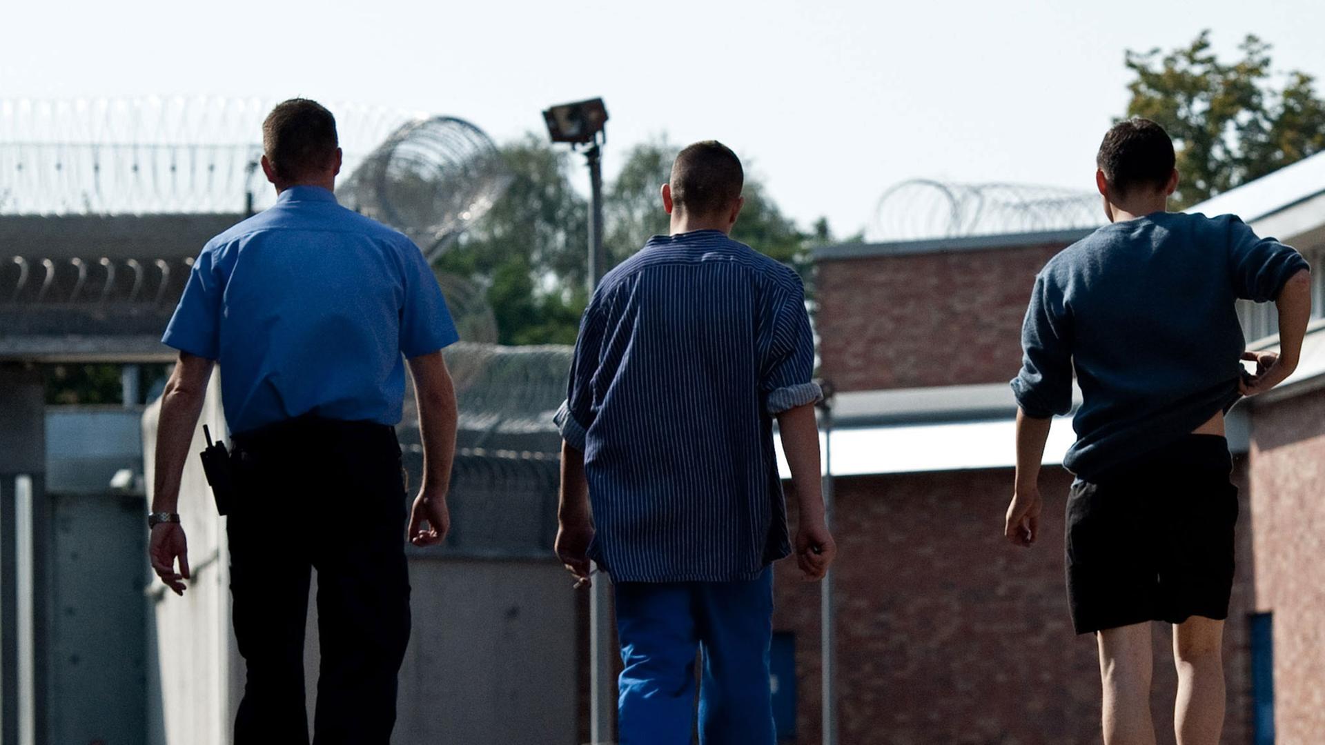 Zwei Gefangene gehen am 18.09.2012 in Betreuung eines Justizangestellten über das Gelände der Untersuchungs- und Jugendhaftanstalt Berlin-Tegel. Zwei Gefangene gehen am 18.09.2012 in Betreuung eines Justizangestellten über das Gelände der Untersuchungs- und Jugendhaftanstalt Berlin-Tegel.