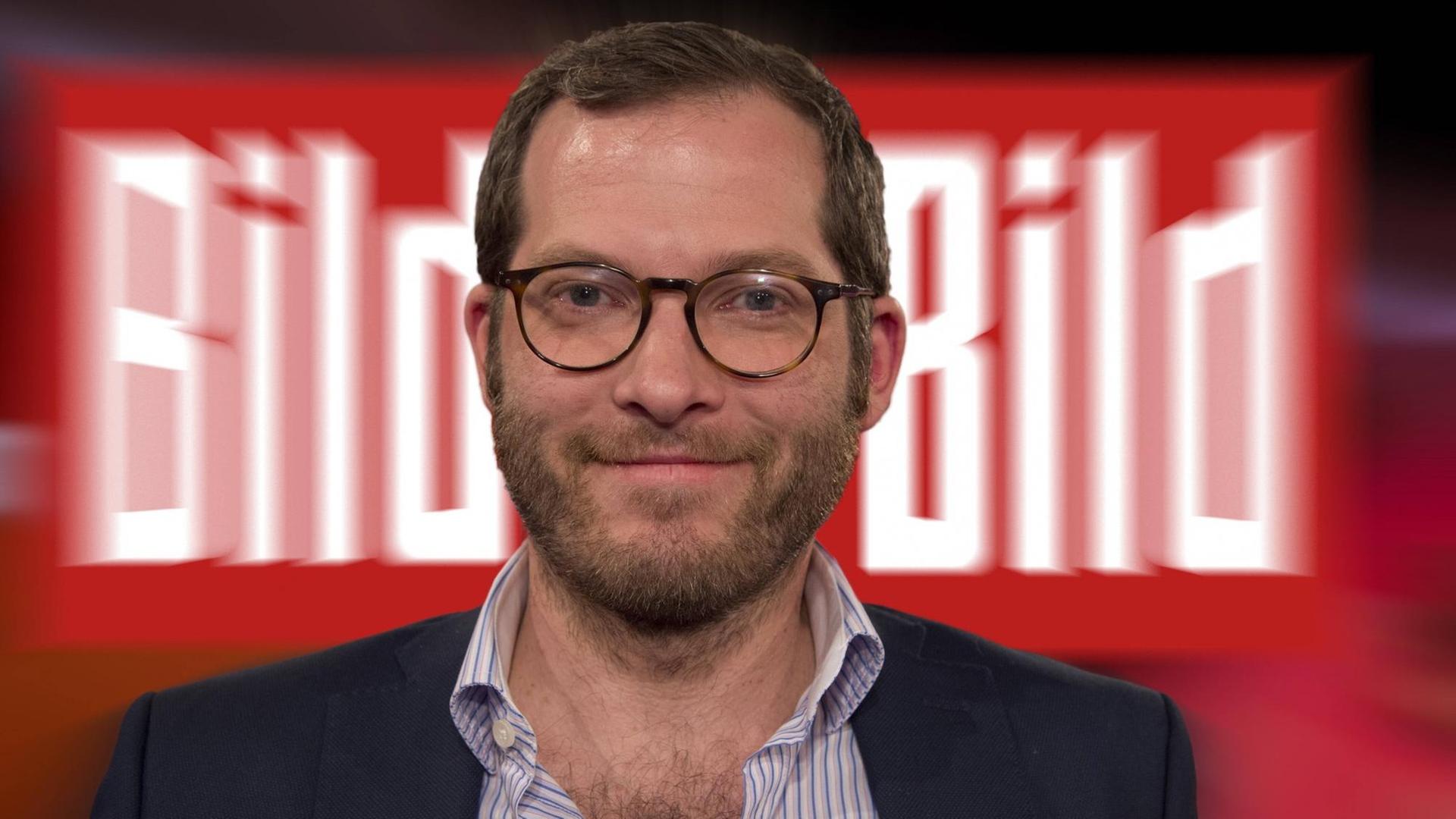 Ein Mann mit offenem Hemdkragen grinst vor zwei "Bild"-Schildern. Der Mann ist Julian Reichelt. Ein Mann mit offenem Hemdkragen grinst vor zwei "Bild"-Schildern. Der Mann ist Julian Reichelt.