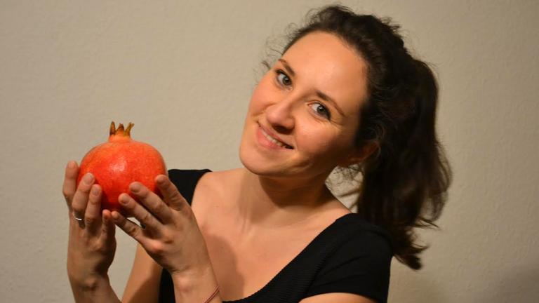 Deniz Julia Güngör hat "Feinsprecher" gegründet, Sprach-Kochkurse in Berlin, sie hält einen Granatapfel in der Hand Deniz Julia Güngör hat "Feinsprecher" gegründet, Sprach-Kochkurse in Berlin, sie hält einen Granatapfel in der Hand