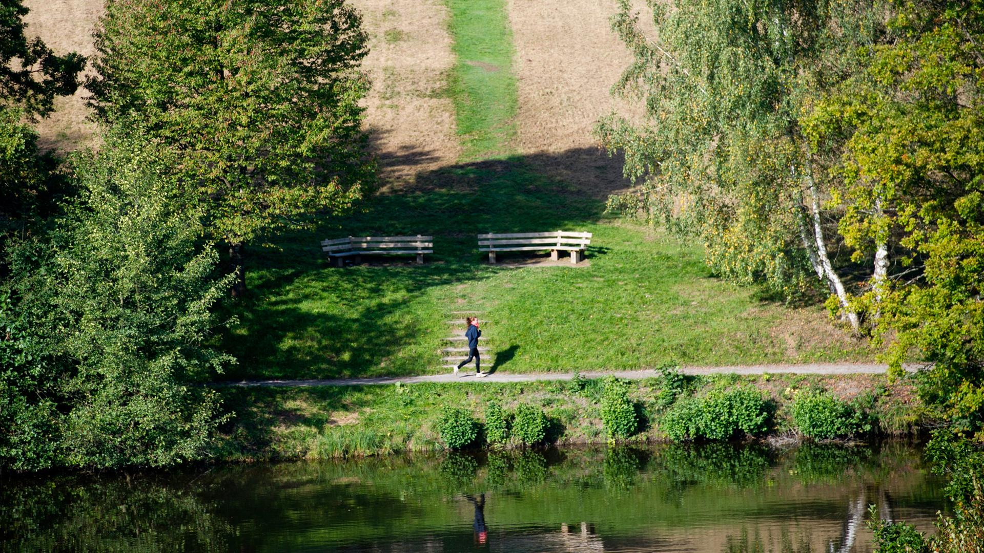 Eine Frau joggt am Bärensee in Stuttgart.