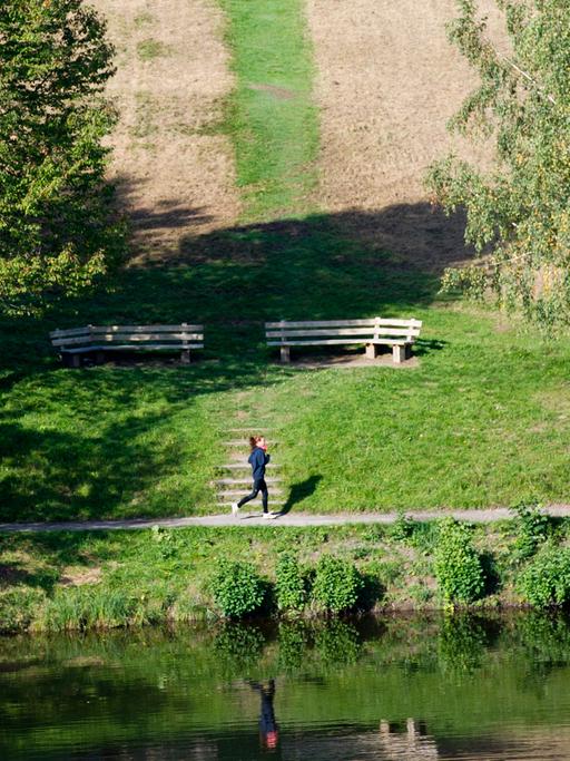 Eine Frau joggt am Bärensee in Stuttgart.