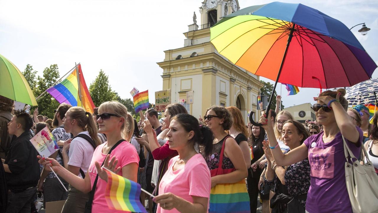 Mit Schirmen und Regenbogenfahnen ziehen Demonstranten durch die Innenstadt von Bialystok. Mit Schirmen und Regenbogenfahnen ziehen Demonstranten durch die Innenstadt von Bialystok.