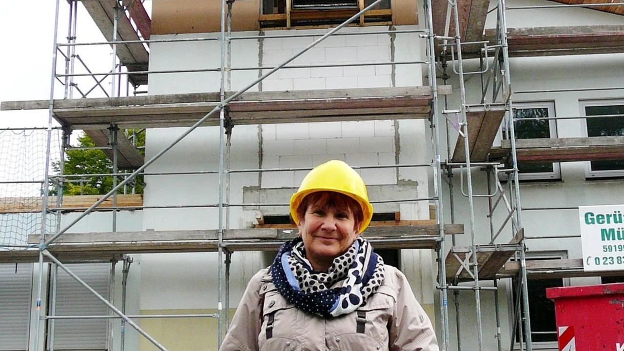 Alexandra Kariakhova vor dem eingerüsteten Kirchturm der evangelischen Kirche in Unna