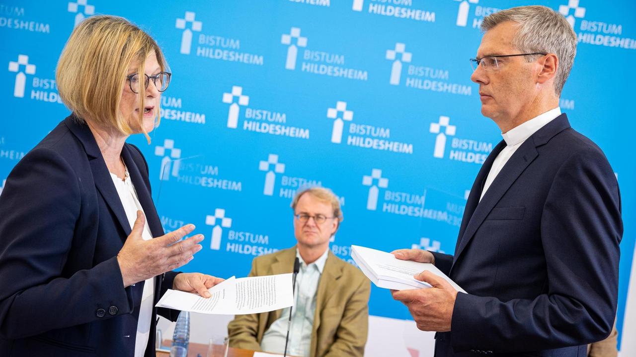 Antje Niewisch-Lennartz, Vorsitzende Richterin am Verwaltungsgericht a. D. und ehemalige Justizministerin in Niedersachsen, übergibt Heiner Wilmer, Bischof von Hildesheim, einen Abschlussbericht zu sexualisierter Gewalt und Machtmissbrauch im Bistum Hildesheim auf einer Pressekonferenz. Eine Gruppe externer Fachleute hat die unabhängige Aufarbeitung von sexualisierter Gewalt und Machtmissbrauch im Bistum Hildesheim abgeschlossen. Antje Niewisch-Lennartz, Vorsitzende Richterin am Verwaltungsgericht a. D. und ehemalige Justizministerin in Niedersachsen, übergibt Heiner Wilmer, Bischof von Hildesheim, einen Abschlussbericht zu sexualisierter Gewalt und Machtmissbrauch im Bistum Hildesheim auf einer Pressekonferenz. Eine Gruppe externer Fachleute hat die unabhängige Aufarbeitung von sexualisierter Gewalt und Machtmissbrauch im Bistum Hildesheim abgeschlossen.