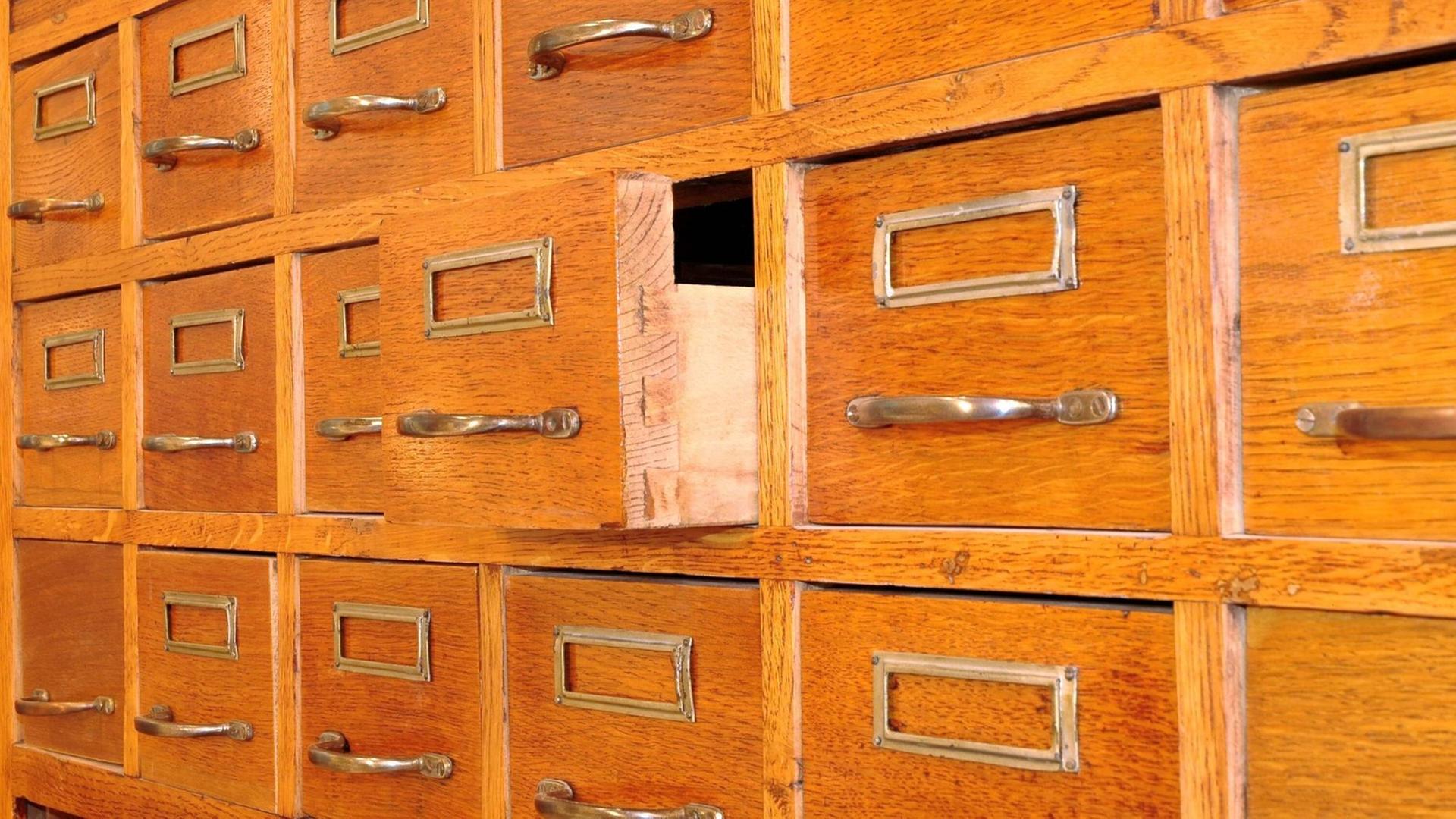 Schubladen in einem hözernen Apothekerschrank, eine steht offen. Schubladen in einem hözernen Apothekerschrank, eine steht offen.