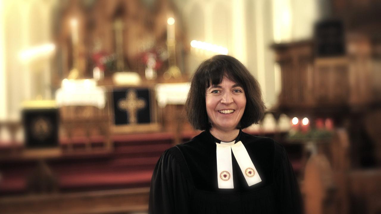 Pastorin Miriam Gross im schwarzen Talar in ihrer Kirche Pastorin Miriam Gross im schwarzen Talar in ihrer Kirche