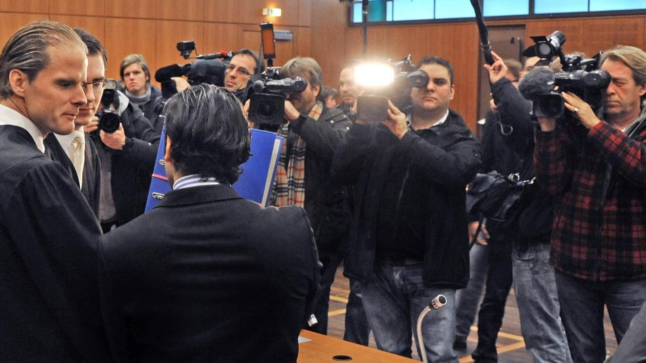 Ein Angeklagter vor dem Landgericht Frankfurt versucht, den Blicken der Öffentlichkeit zu entgehen. /Symbolbild