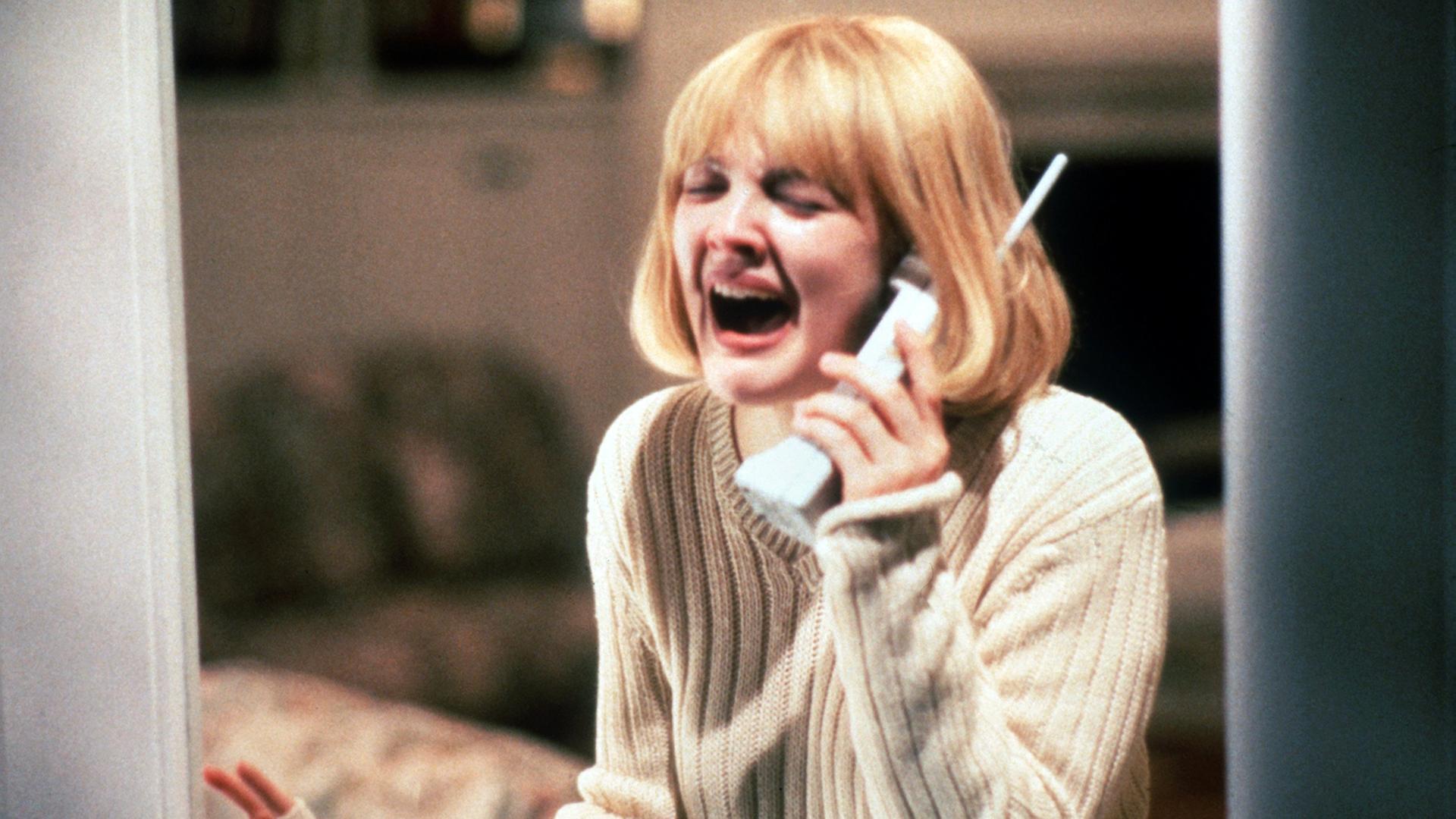 Filmstill aus "Scream" von Wes Craven mit Drew Barrymore als Casey, verzweifelt am Telefon, wo ihr Mörder sie terrorisiert.