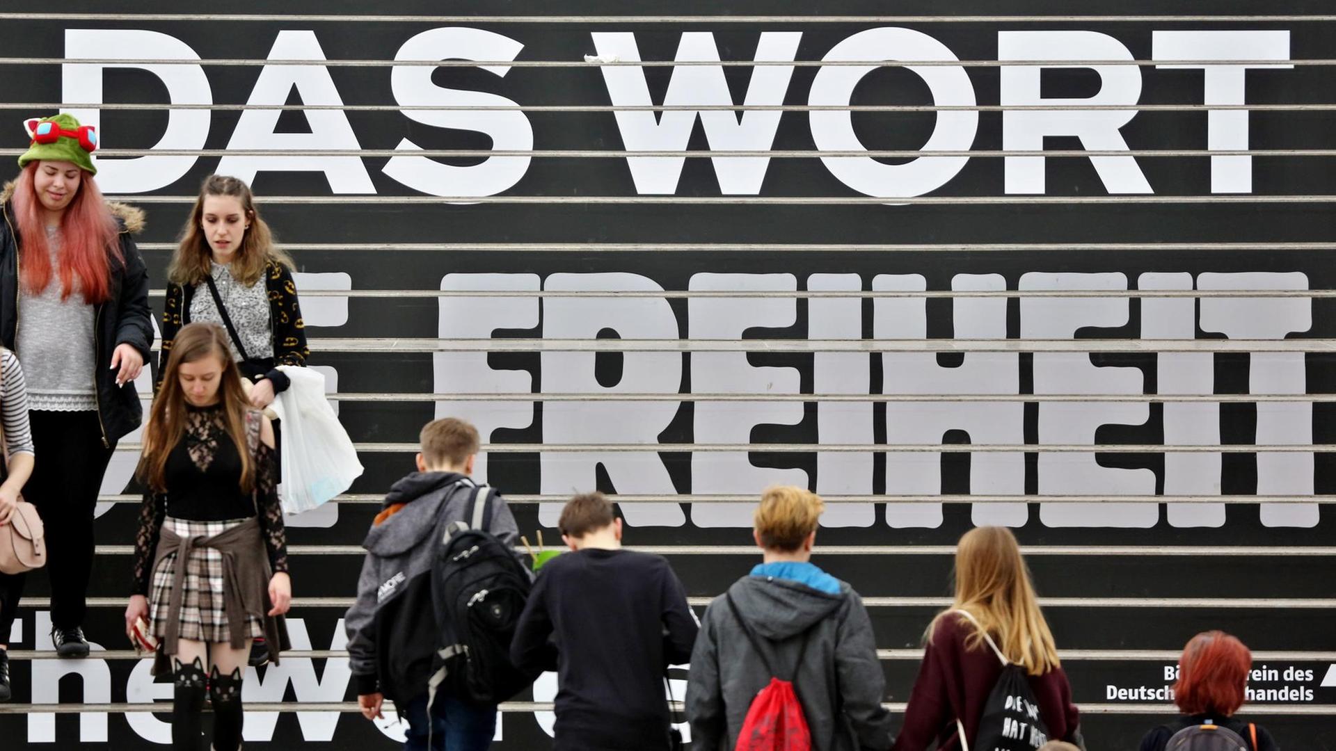 Besucher gehen am 23.03.2017 über eine Treppe mit den Schriftzug "Für das Wort und die Freiheit" auf der Buchmesse in Leipzig. Besucher gehen am 23.03.2017 über eine Treppe mit den Schriftzug "Für das Wort und die Freiheit" auf der Buchmesse in Leipzig.