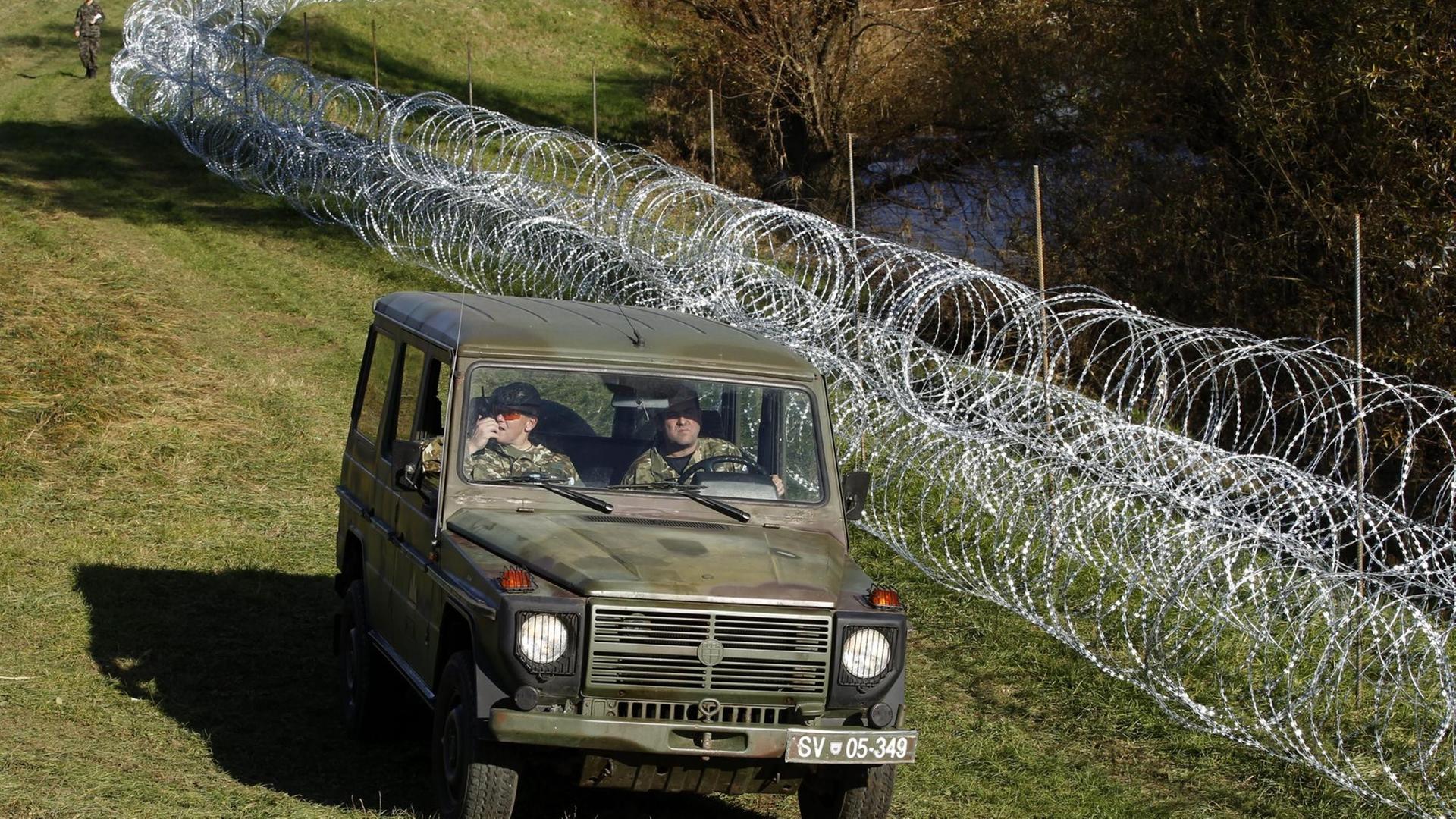 Armeefahrzeug neben einem Stacheldrahtzaun. Armeefahrzeug neben einem Stacheldrahtzaun.