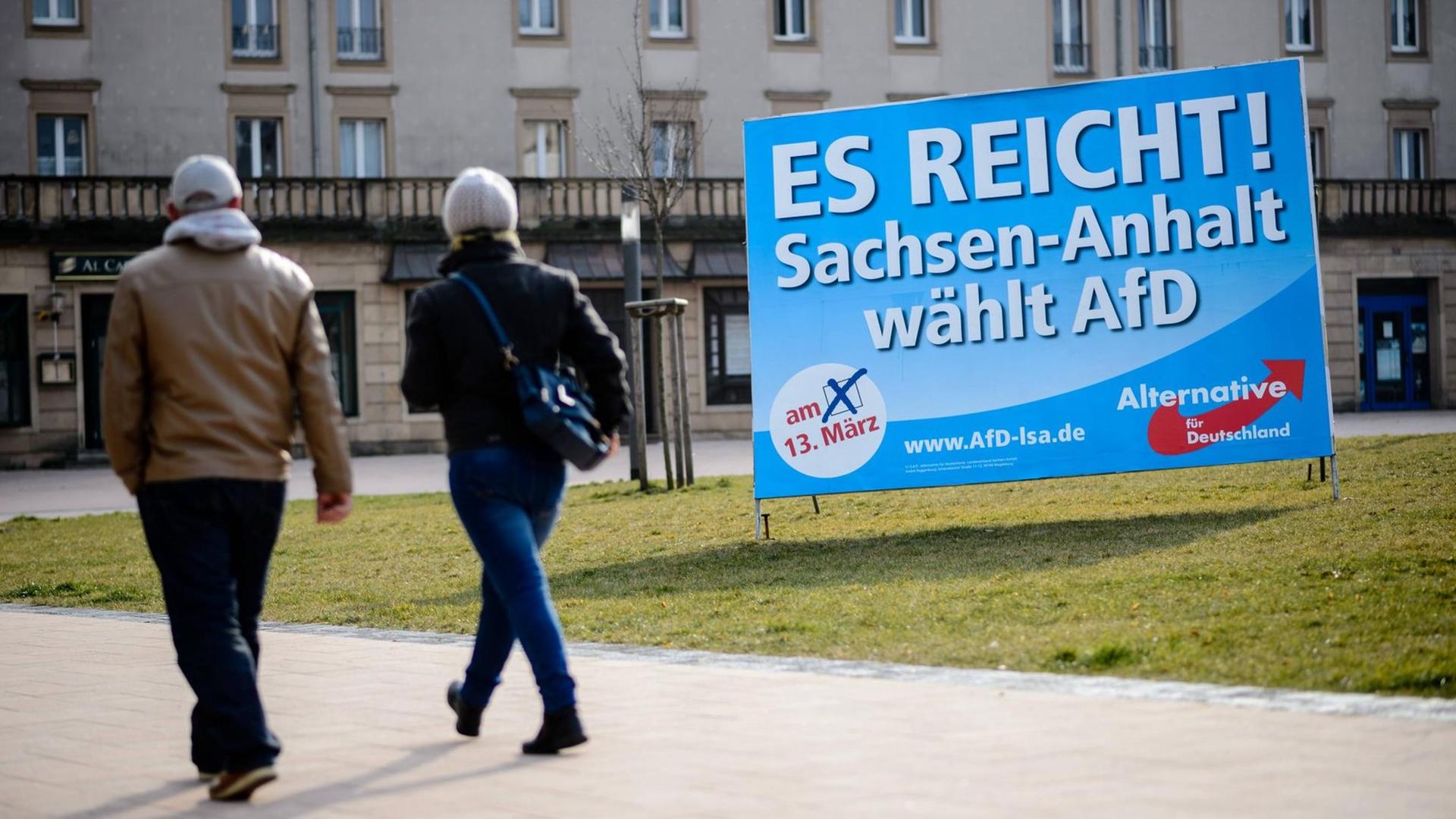 Zwei Menschen gehen in Merseburg in Sachsen-Anhalt an einem Wahlplakat der Alternative für Deutschland vorbei Zwei Menschen gehen in Merseburg in Sachsen-Anhalt an einem Wahlplakat der Alternative für Deutschland vorbei