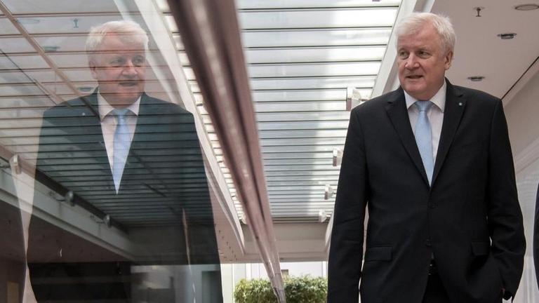 Horst Seehofer spiegelt sich auf dem Weg in einem Gang in der Staatskanzlei. Rechts läuft ein Sicherheitsbeamter. Horst Seehofer spiegelt sich auf dem Weg in einem Gang in der Staatskanzlei. Rechts läuft ein Sicherheitsbeamter.
