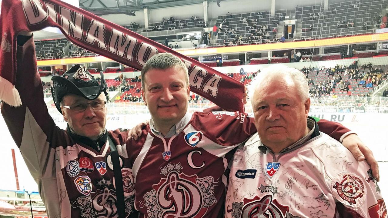 Drei Fans des Eishockeyvereins Dinamo Riga in rot-weißen Trikots Drei Fans des Eishockeyvereins Dinamo Riga in rot-weißen Trikots