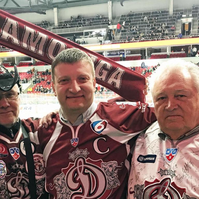 Drei Fans des Eishockeyvereins "Dinamo Riga" in rot-weißen Trikots
