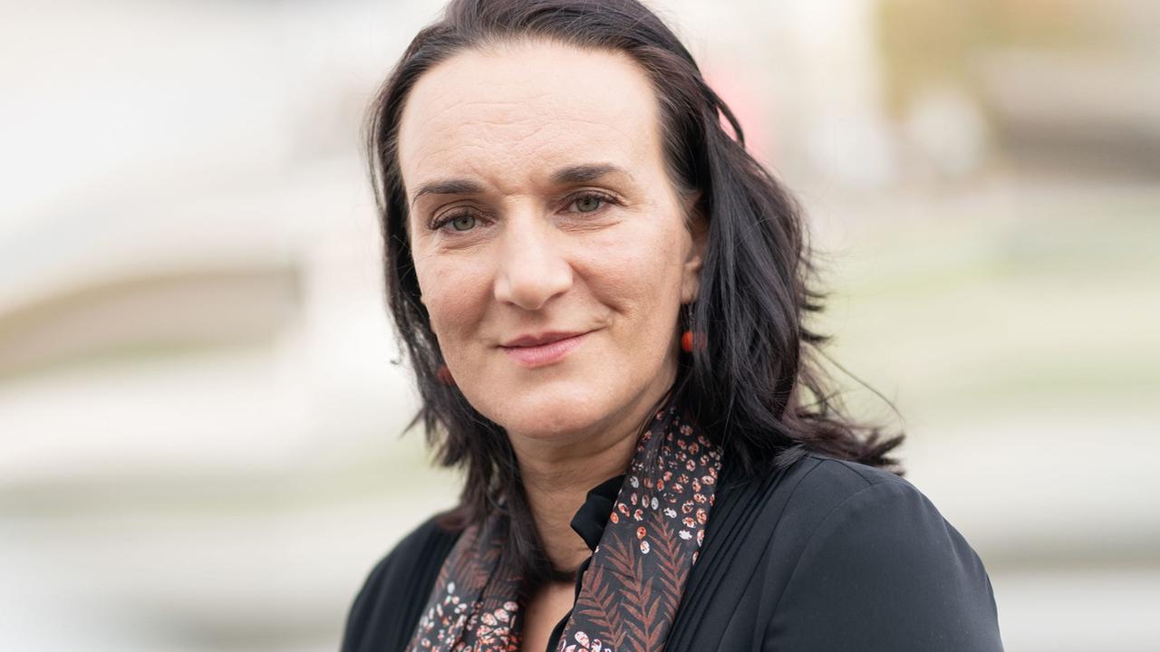 Porträt einer Frau mit schwarzen glatten Haaren, die direkt in die Kamera blickt. Porträt einer Frau mit schwarzen glatten Haaren, die direkt in die Kamera blickt.