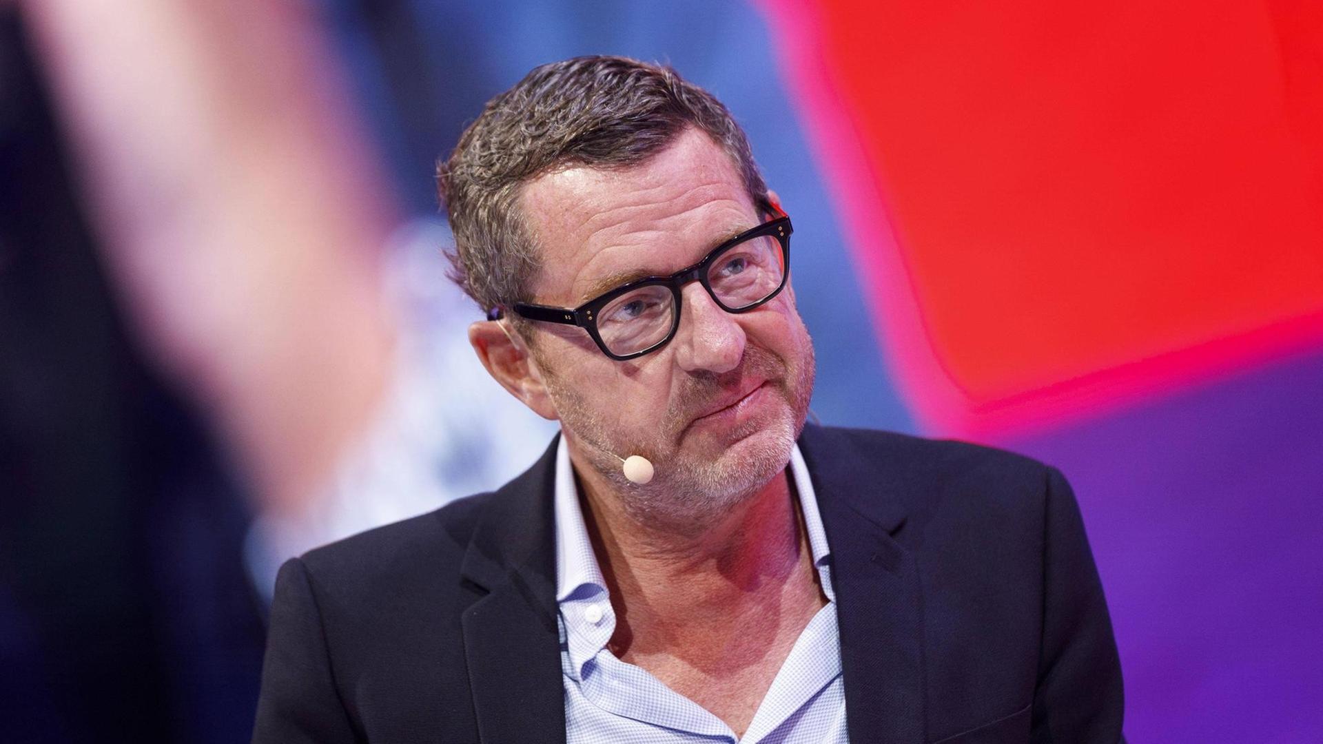 Kai Diekmann sitzt auf einer Bühne Kai Diekmann sitzt auf einer Bühne