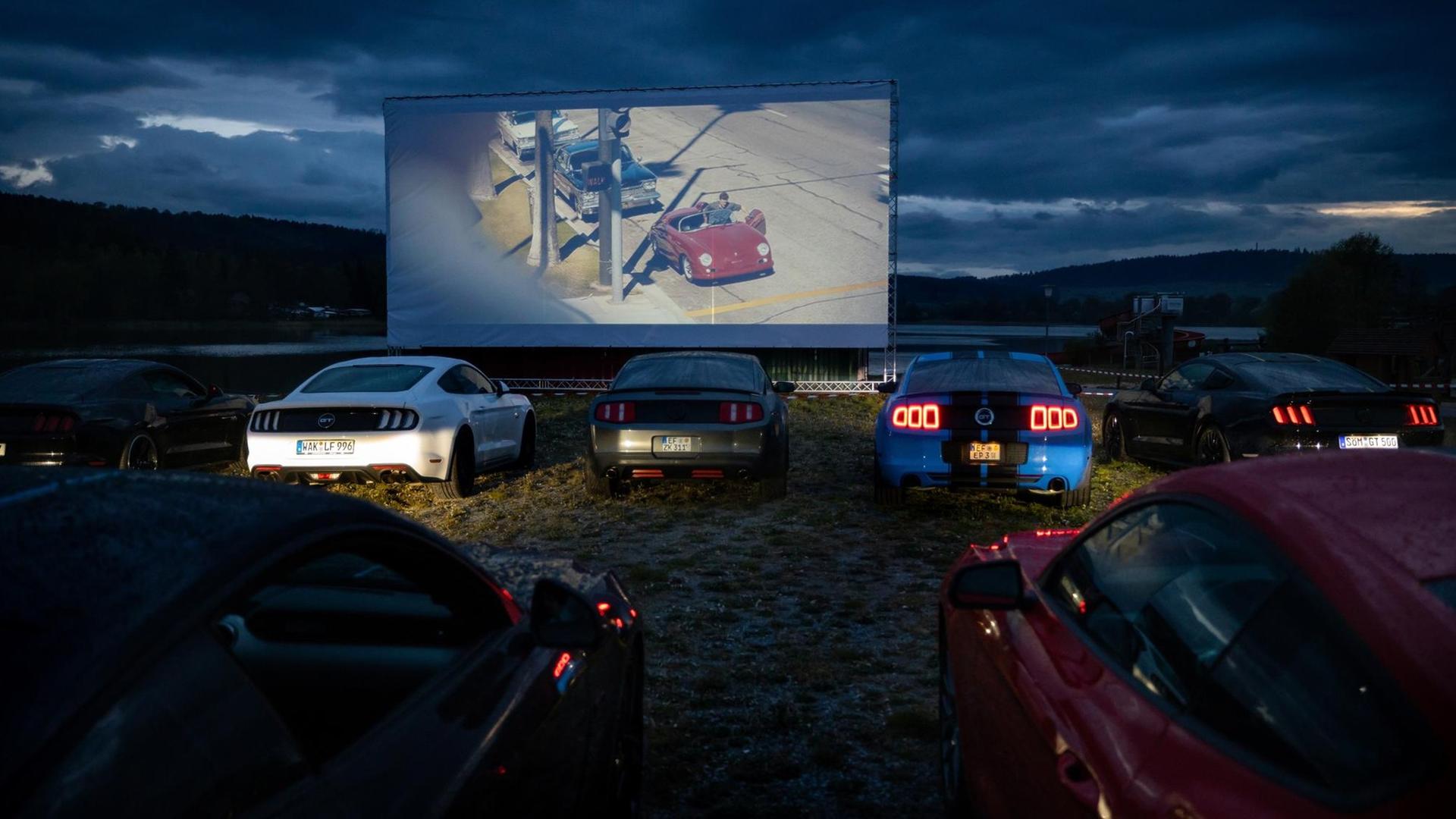 28.04.2020, Thüringen, Hohenfelden: Autos stehen beim Testlauf vor der großen Leinwand am Stausee Hohenfelden, bevor ab dem 29.4.2020 hier vorerst jeden Abend ein Film im 150 PKW fassenden Autokino gezeigt wird. In Thüringen sind Autokinos wieder erlaubt, da im eigenen Wagen die Regeln für die soziale Distanz mit Sicherheit eingehalten werden können. 28.04.2020, Thüringen, Hohenfelden: Autos stehen beim Testlauf vor der großen Leinwand am Stausee Hohenfelden, bevor ab dem 29.4.2020 hier vorerst jeden Abend ein Film im 150 PKW fassenden Autokino gezeigt wird. In Thüringen sind Autokinos wieder erlaubt, da im eigenen Wagen die Regeln für die soziale Distanz mit Sicherheit eingehalten werden können.