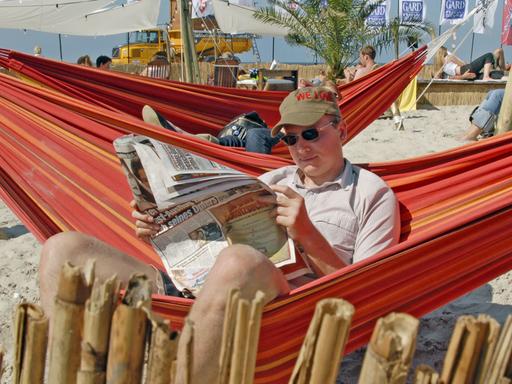 Ein Gast eines Beach-Clubs am Strand von St. Peter-Ording genießt am Freitag (24.08.2007) bei sonnigem Wetter seine Lektüre.