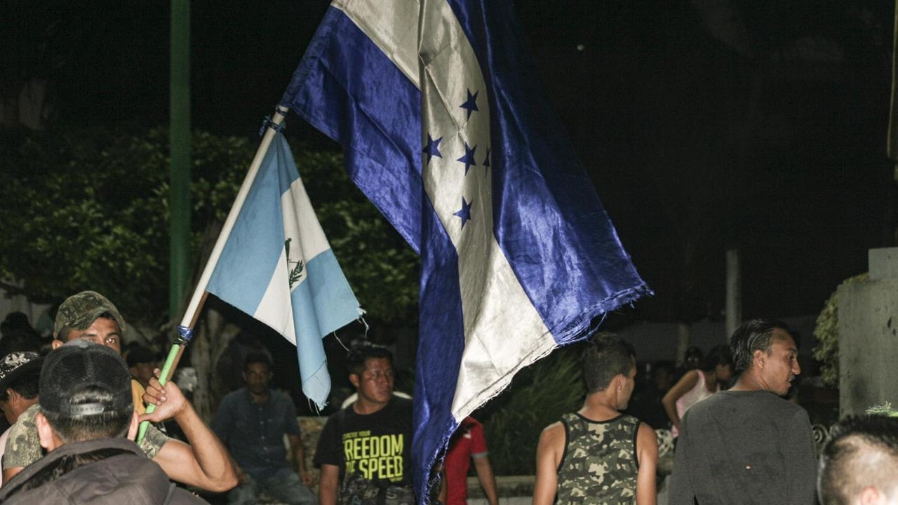 Flagge von Honduras wird von Migrant gehlaten Flagge von Honduras wird von Migrant gehlaten